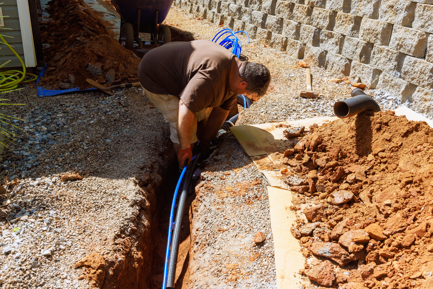 Plumber trenching an exterior water line during a slab leak reroute in Murrieta, CA